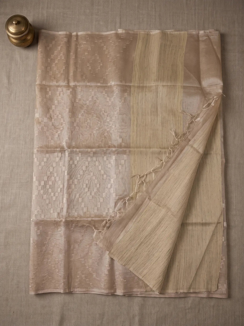 Linen-colour kota tissue saree displayed flat with geometric zari embroidery, striped pallu and tasselled edge