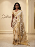 Model wearing an off-white semi tussar silk saree with Rajasthani folk motif embroidery and gold-toned border